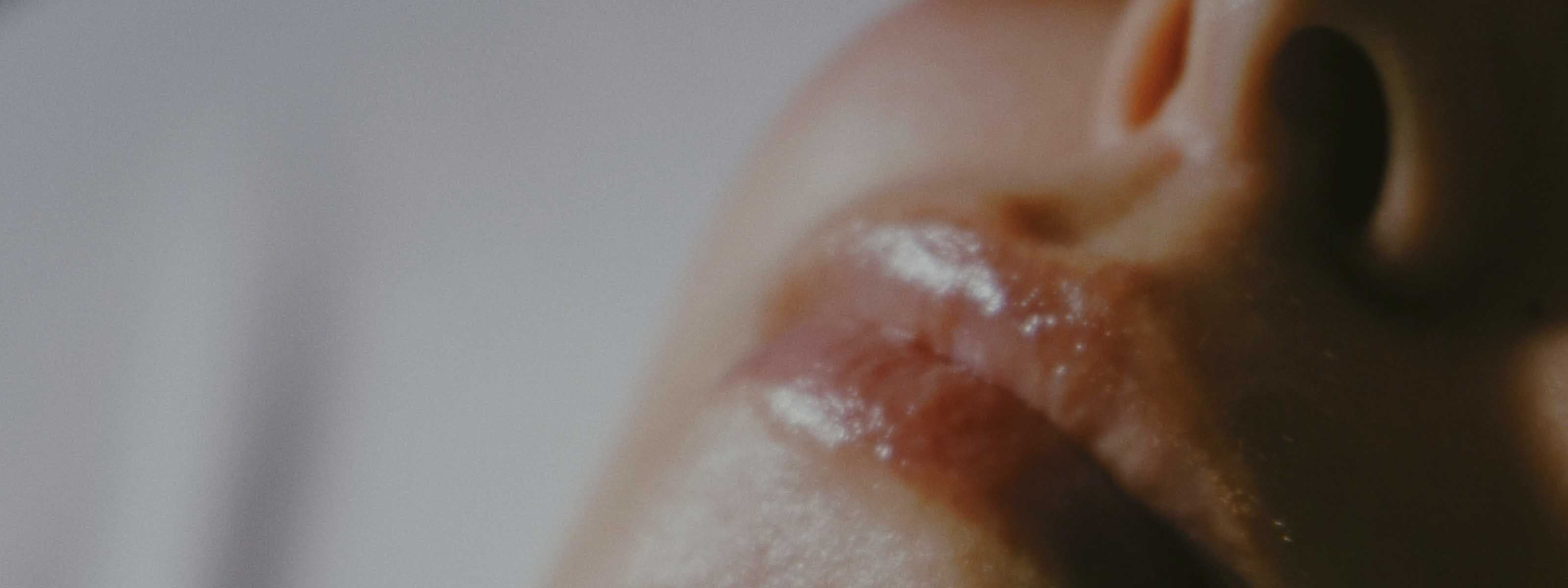 Close-up portrait of lips and nose with soft, cinematic lighting.