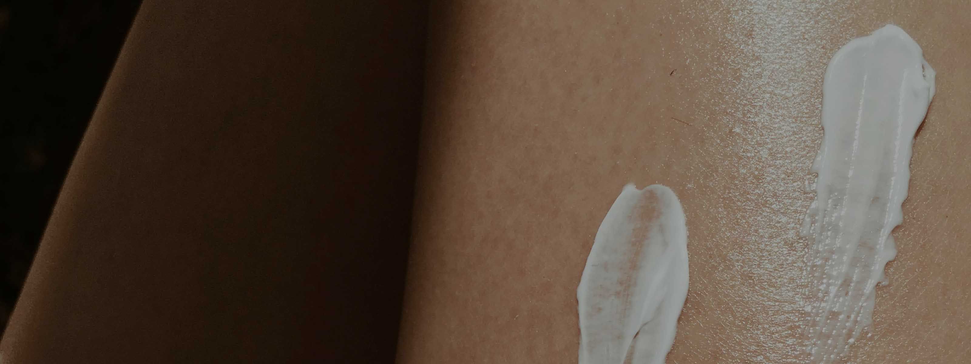 Two swipes of white moisturizer or lotion on bare skin.