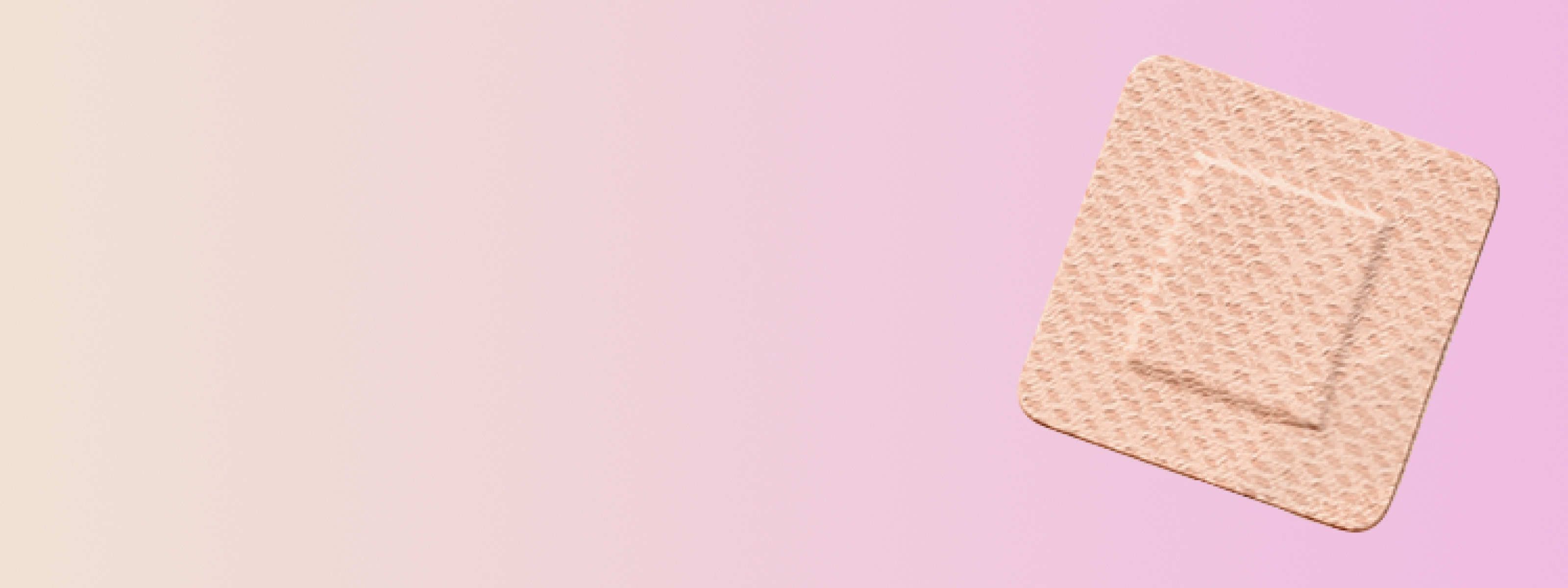 a birth control patch in front of a pink background