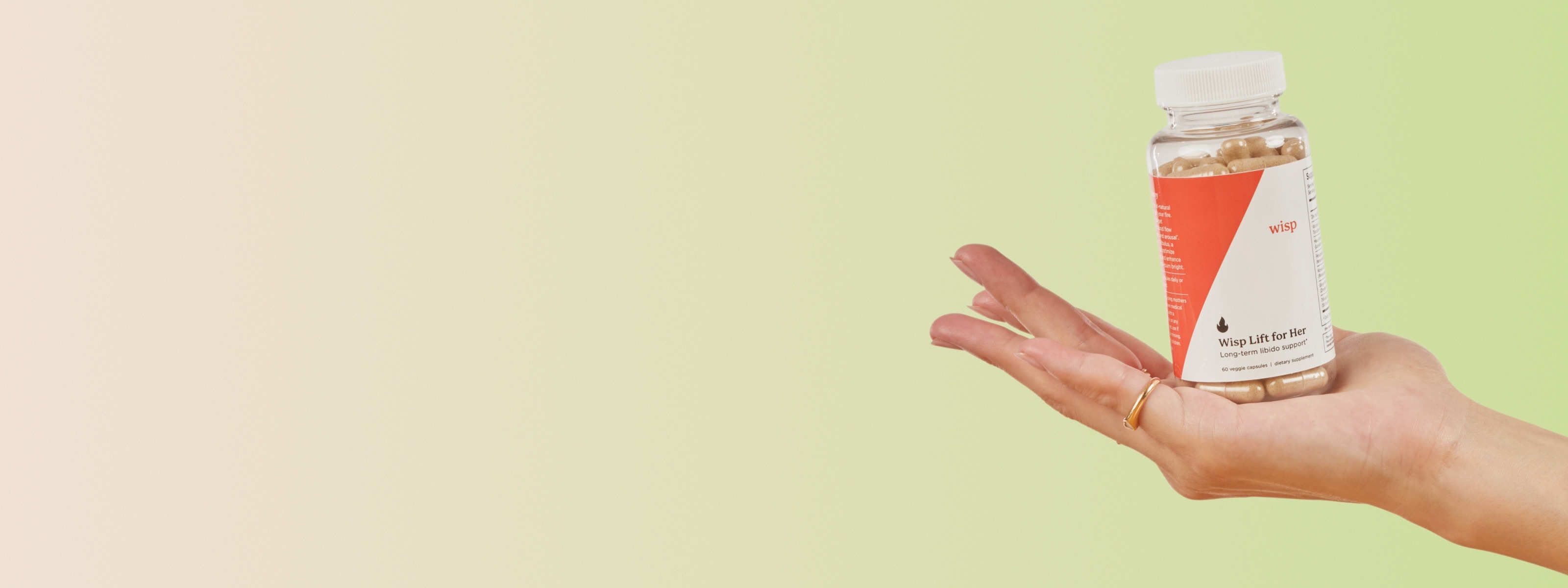 Woman's hand holding Wisp Lift for Her Libido Supplements on a green background