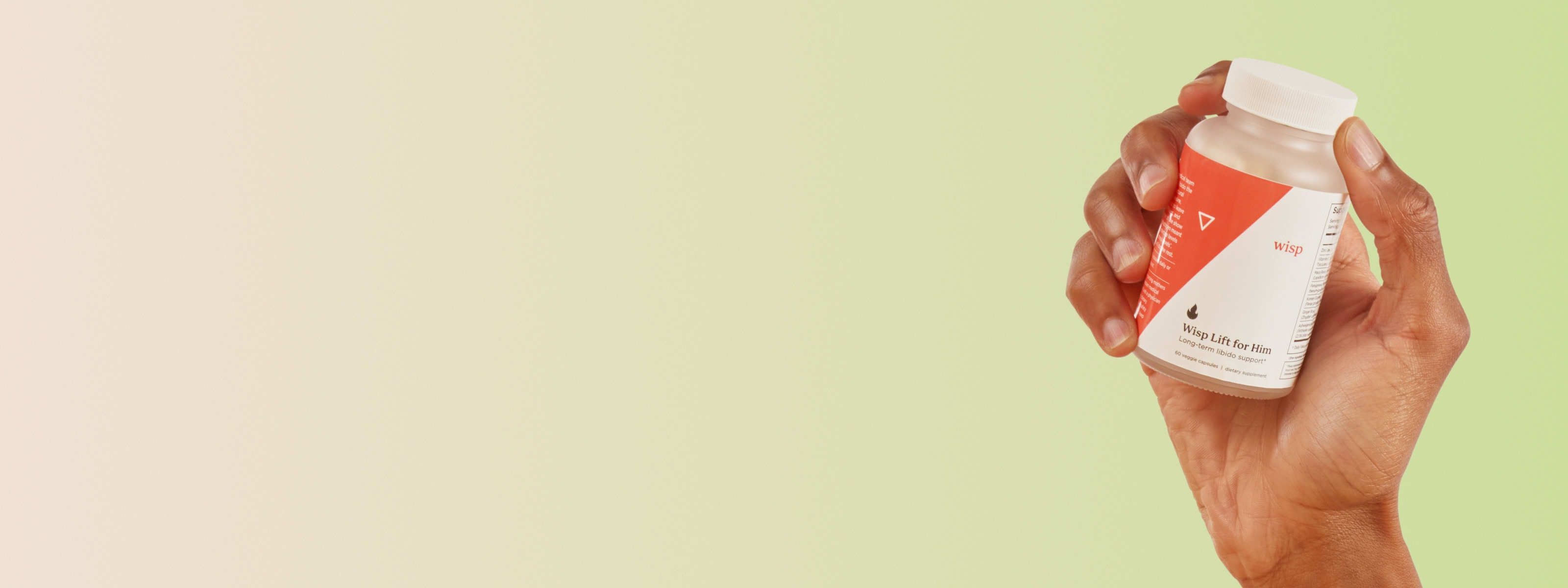 Man's hand holding Wisp Lift for Him Libido Supplements on a green background