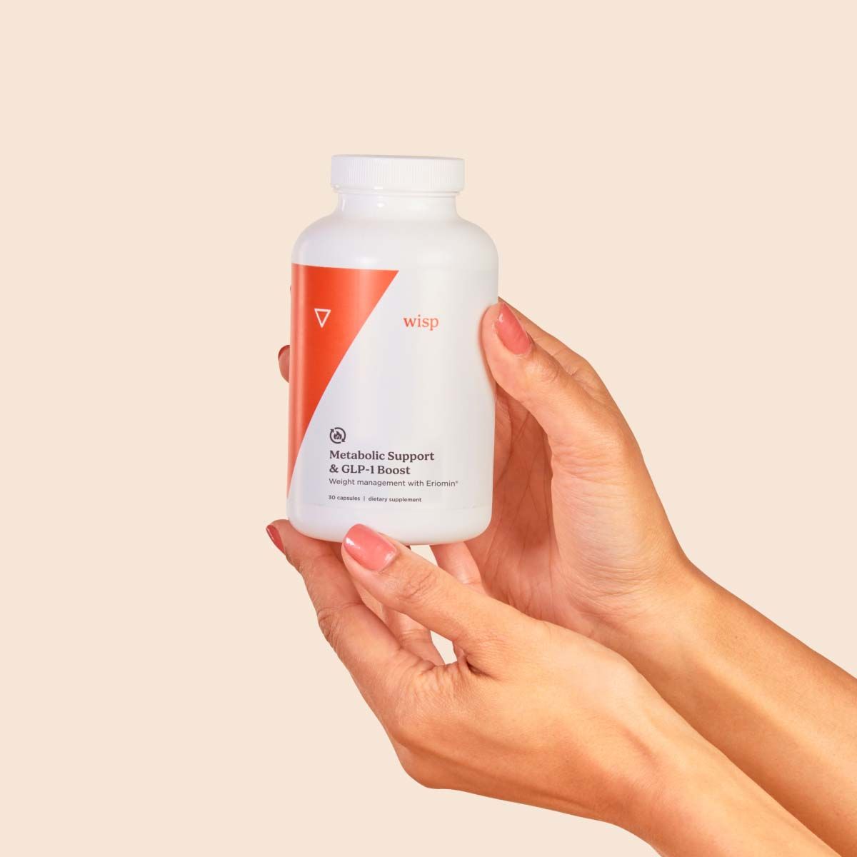A hand holding a Wisp Metabolic bottle with a cream background