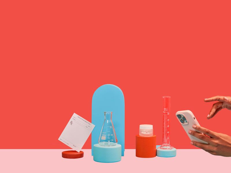 Woman's hand holding phone with wisp pill bottles, test tubes and rx form on red and blue background