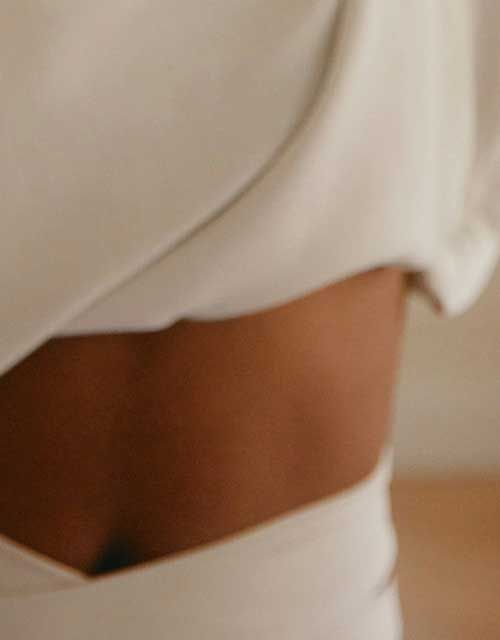 A close up of a woman's midsection wearing white lounge clothing