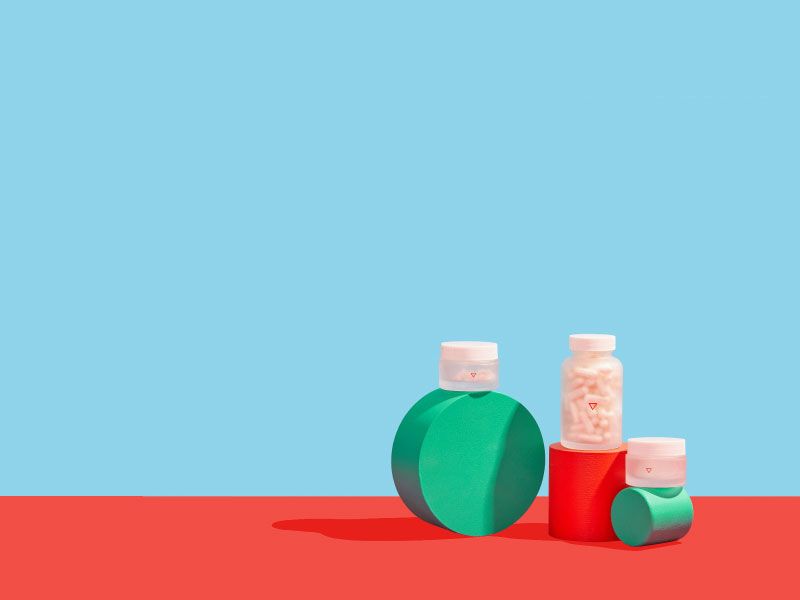 Wisp pill bottles stack on colorful abstract shapes on a red and blue background