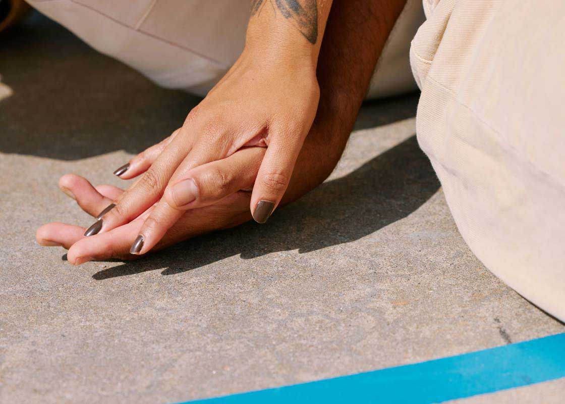 A man and woman holding hands outside