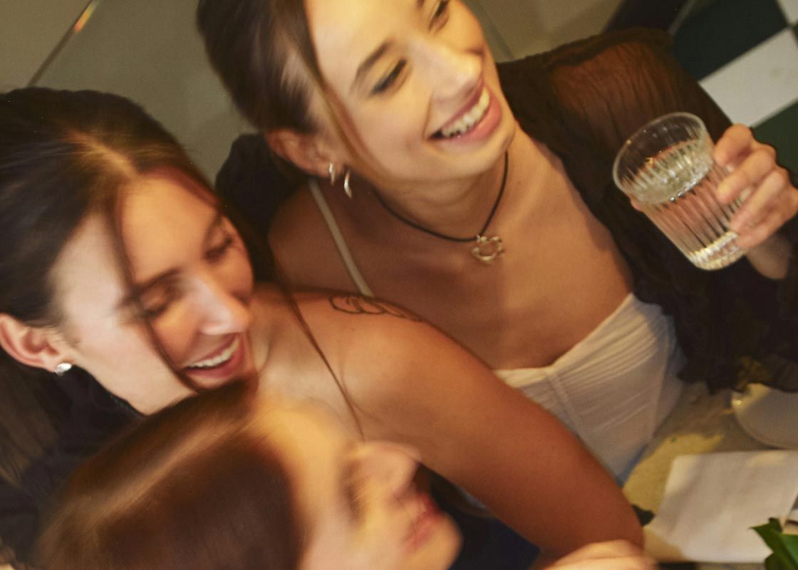 A group of smiling women at an event with motion blur