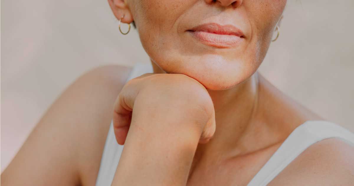 Close up of the bottom half of a face against a gray background