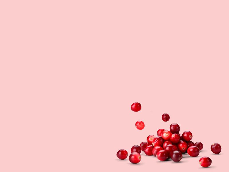 a pile of cranberries on a pink background