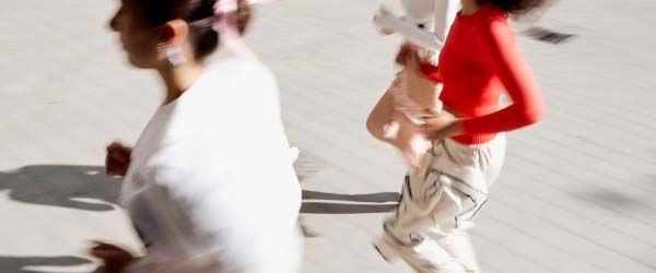 A group of women outdoors running with motion blur