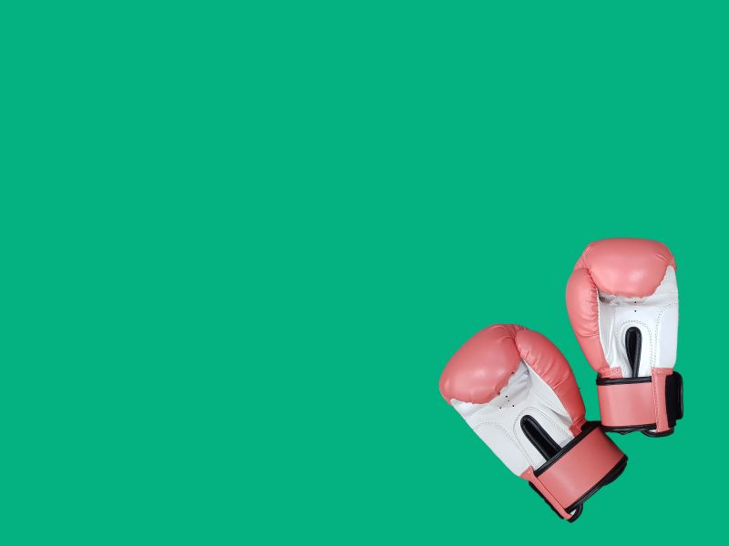 Pink boxing gloves on a green surface