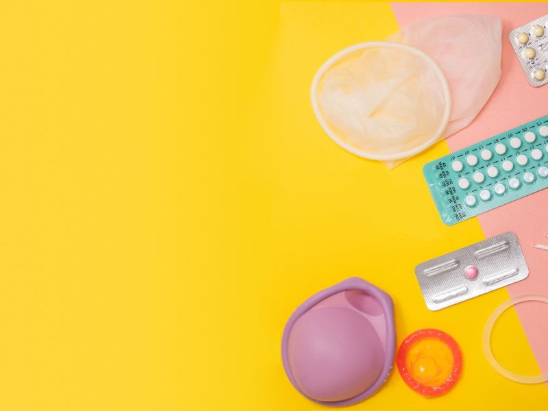 Multiple types of contraceptives on a yellow and pink background