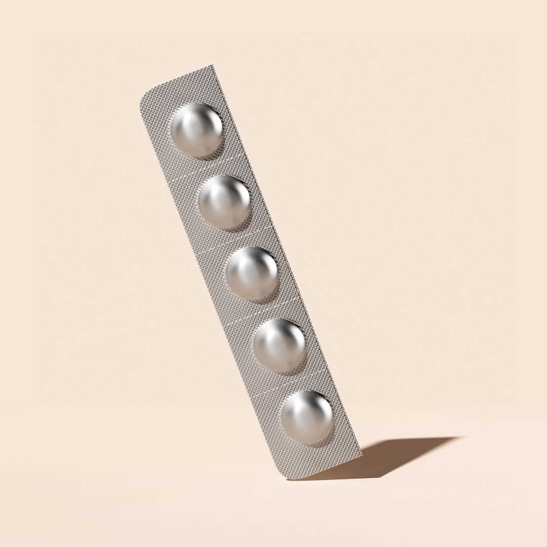 A Zofran pill packet balanced on a cream surface