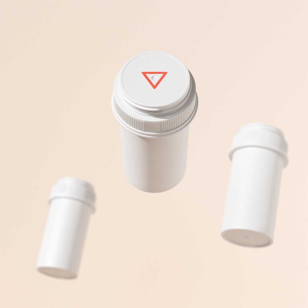 3 floating Wisp pill vials with a cream background