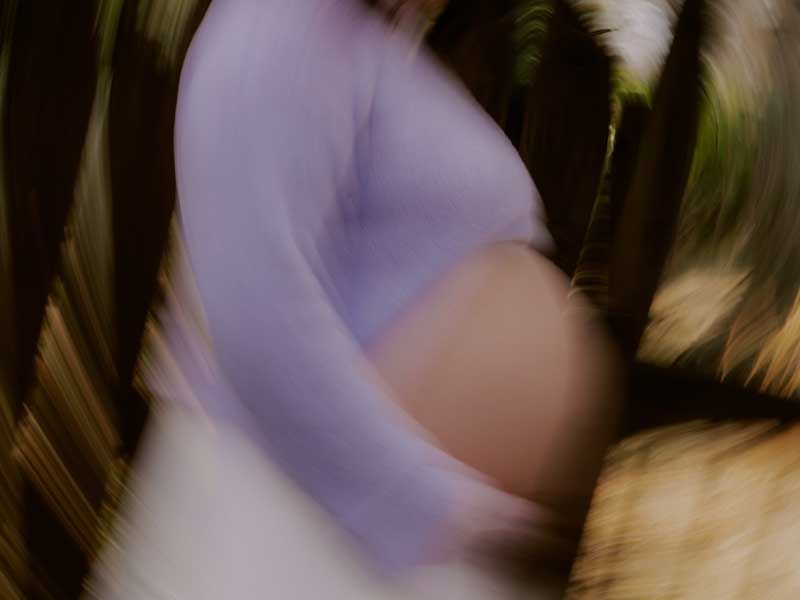 Soft blurred close up of a pregnant torso in motion