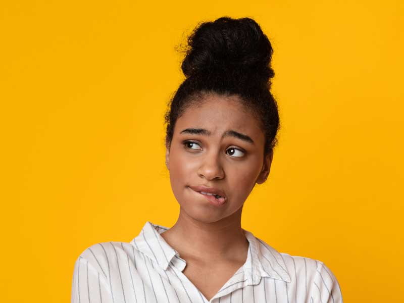 A woman wearing a striped collar shirt has a confused look on her face