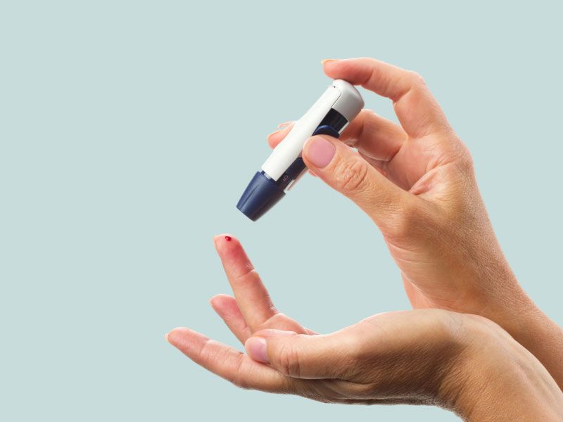A person is using a lancet to prick their finger for a blood test