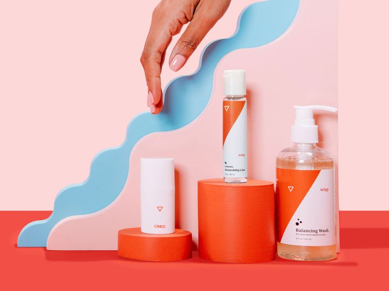 a woman's hand reaches for Wisp intimate care products on a colorful geometric background