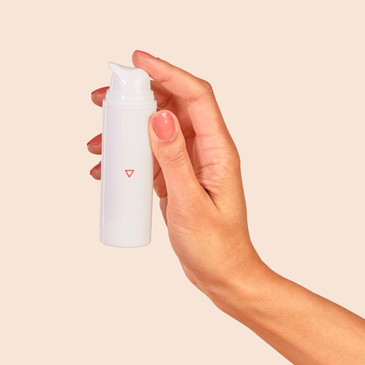 A bottle of Topical Spironolactone in someone's hand with a cream surface