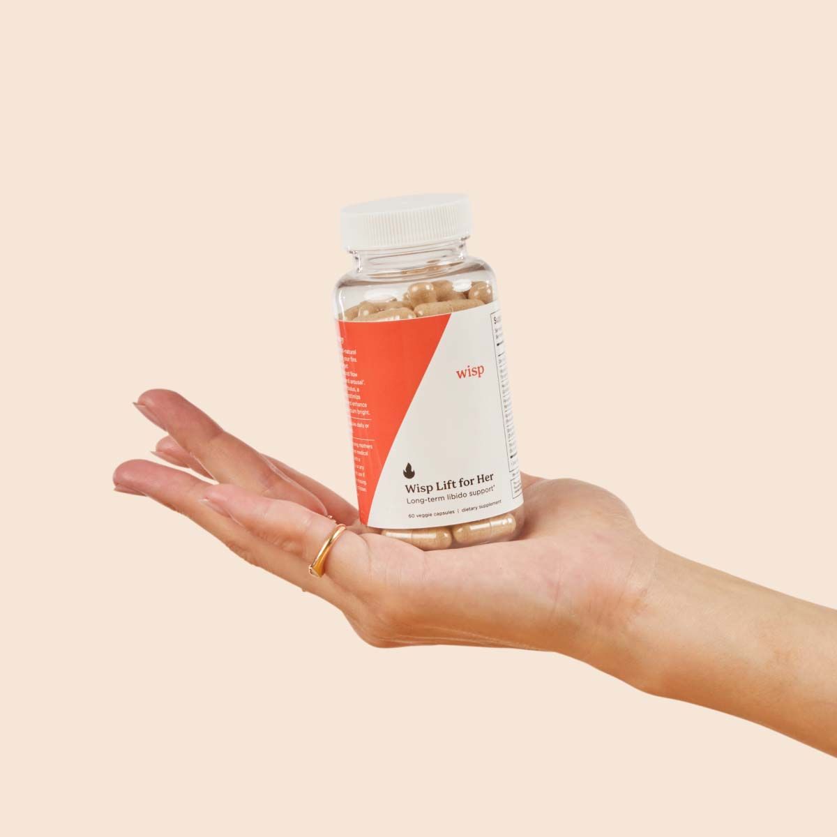 Wisp Lift Libido Supplements for Her in a person's hand with a cream background
