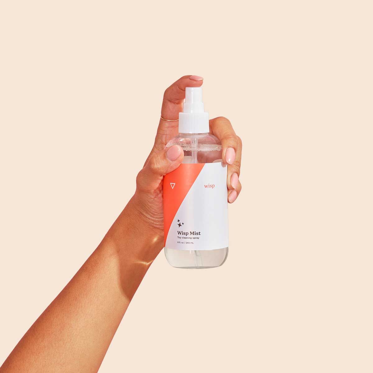 Wisp Mist in a person's hand with a cream background