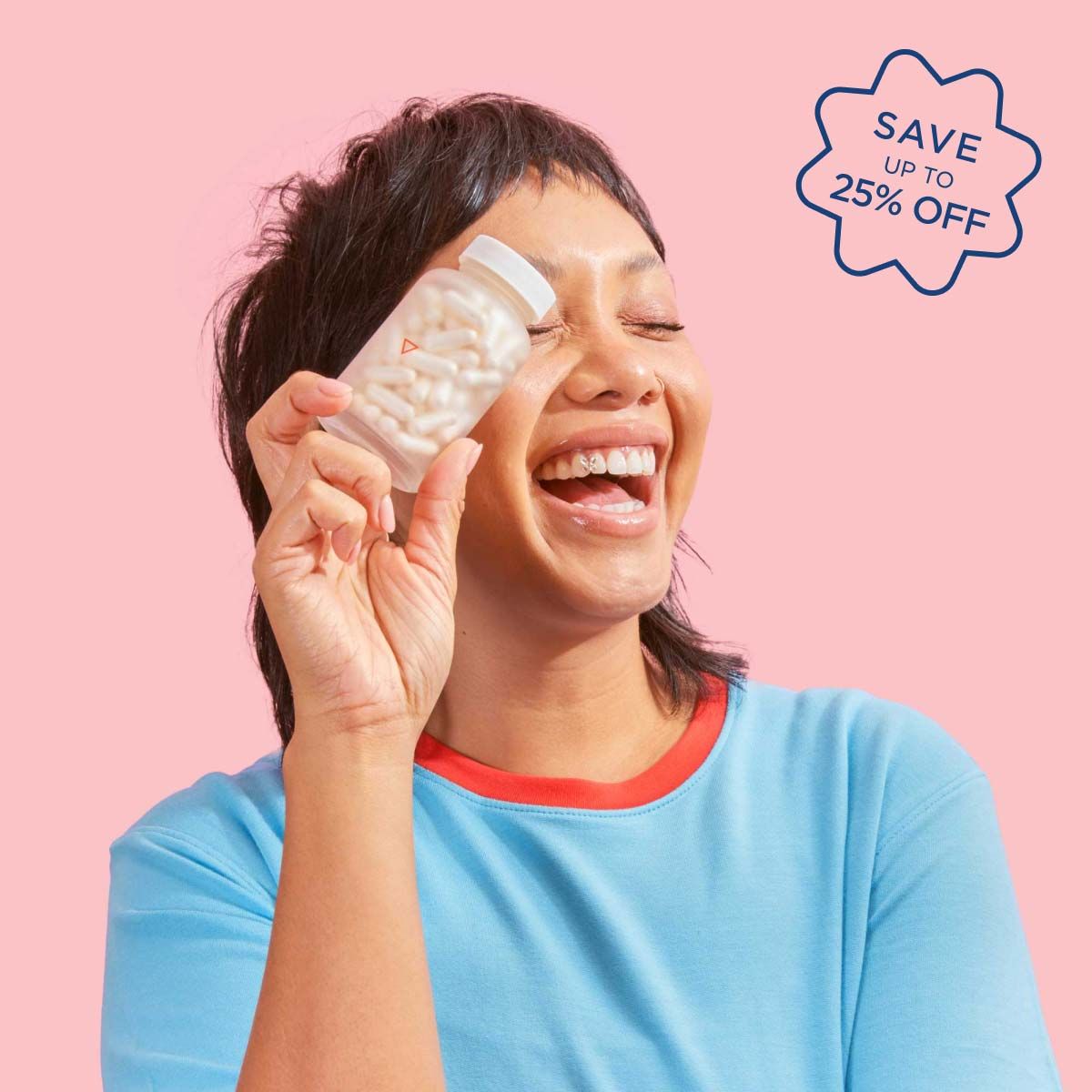 A woman smiling and wearing a blue shirt while holding a Wisp glass pill jar in front of a pink background