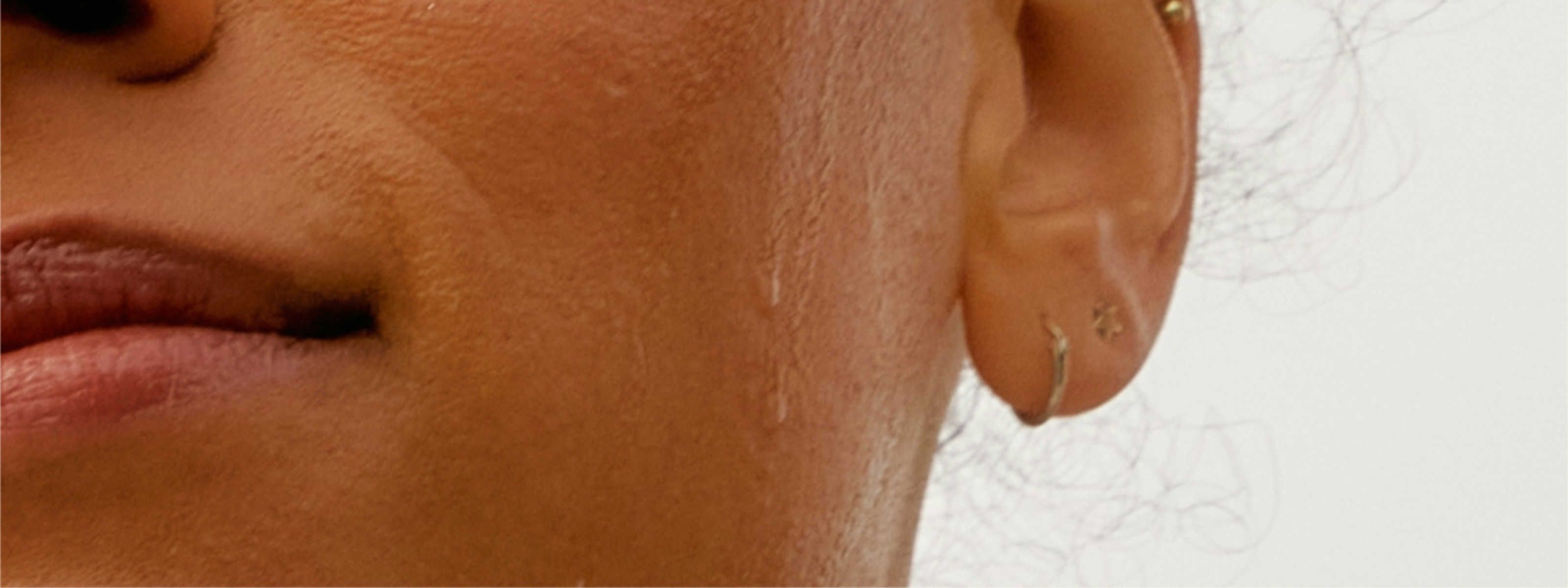 image of woman's face with sweat dripping down her cheek