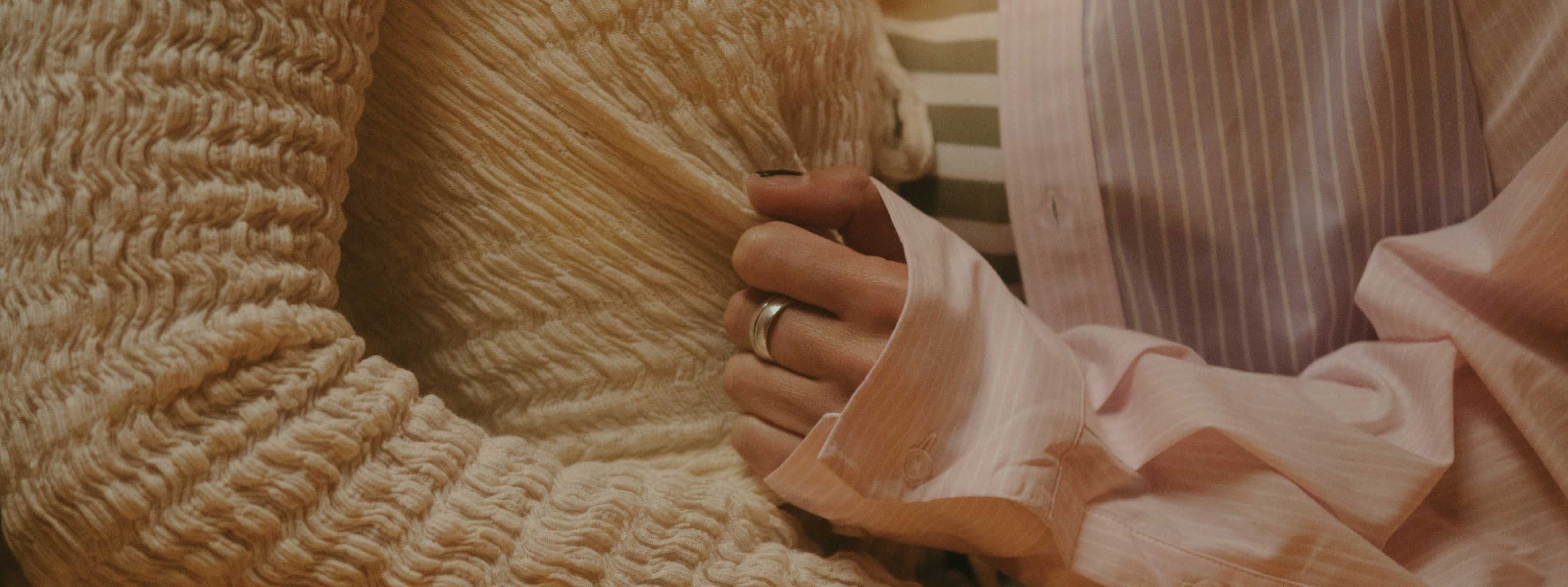 A close up of two people in an intimate embrace. One person tugging the other's shirt