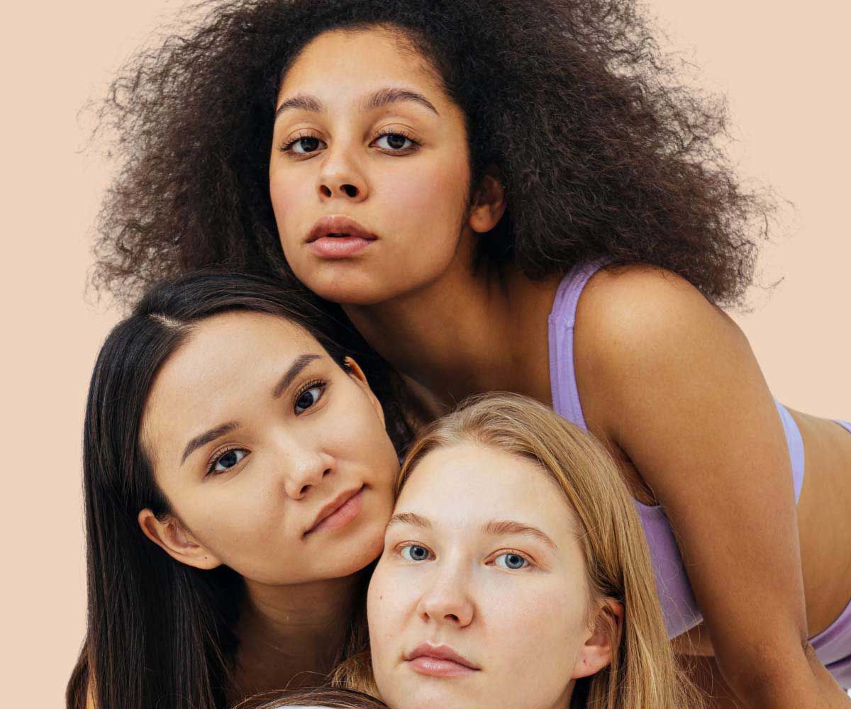 3 women with neutral expressions with a cream background