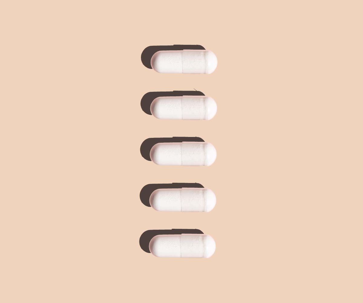 5 white capsules on a beige background