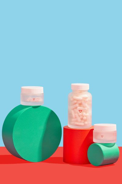 Wisp pill bottles stack on colorful abstract shapes on a red and blue background