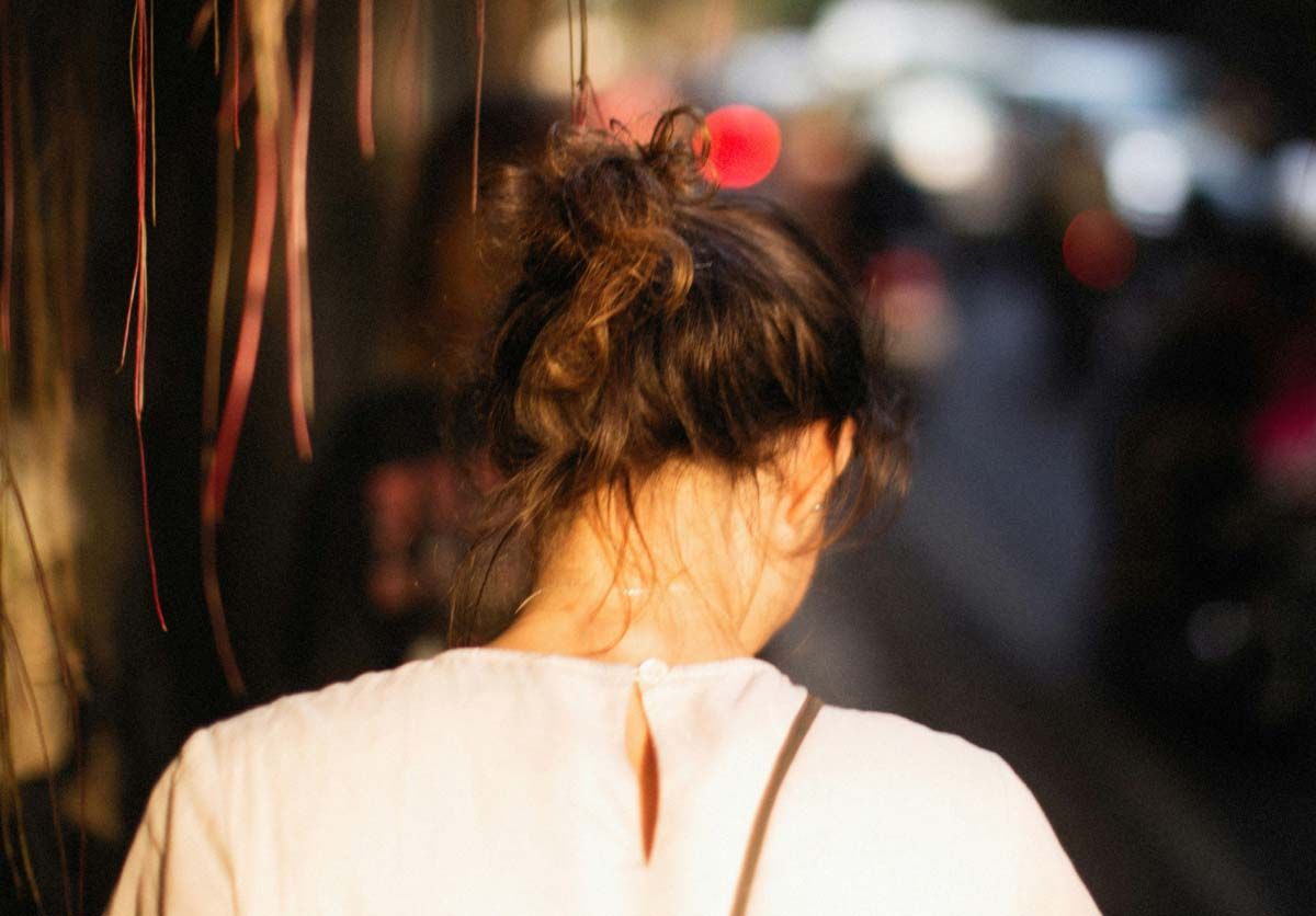 The back of a woman walking down a city street
