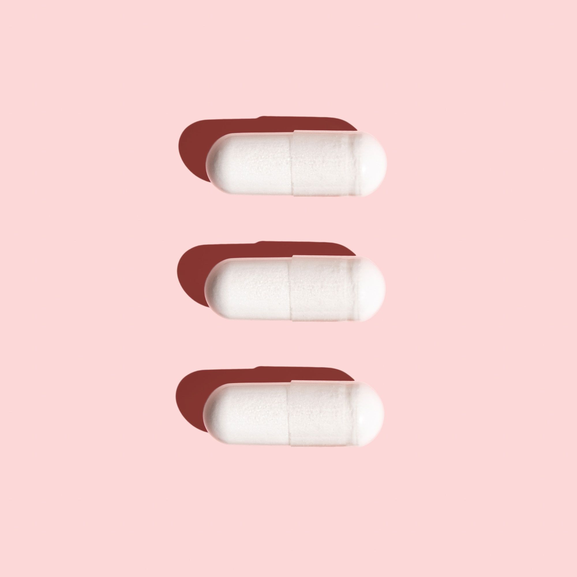Lysine capsules on pink background
