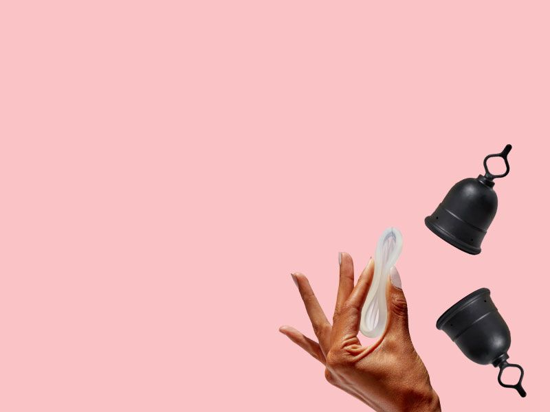 A woman's hand holding the Flex Disc next two two Flex Menstrual Cups with a pink background