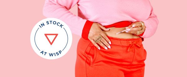 A woman wearing red shorts and a pink sweater injects GLP-1 weight loss medication to her stomach