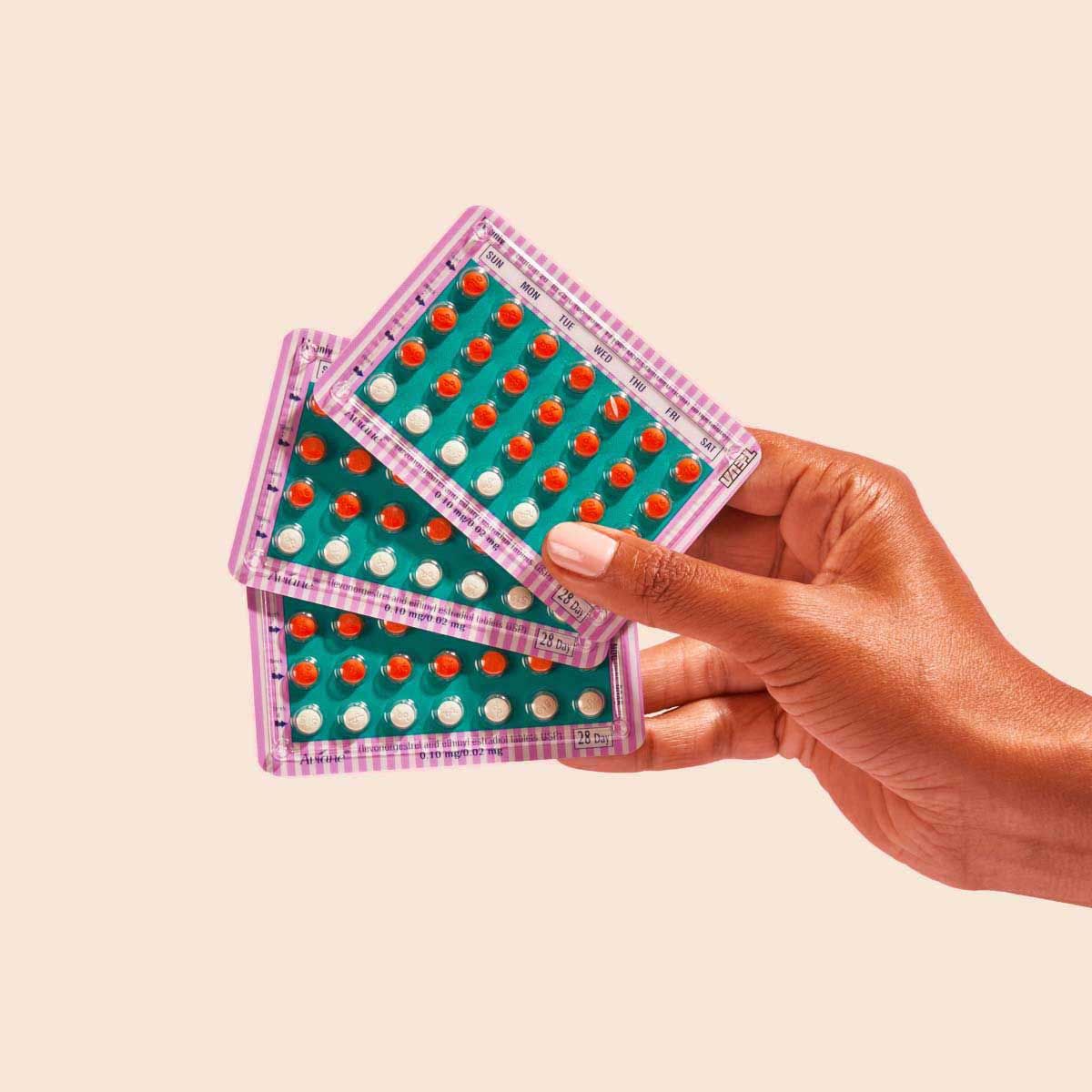 Woman holding colorful birth control packets