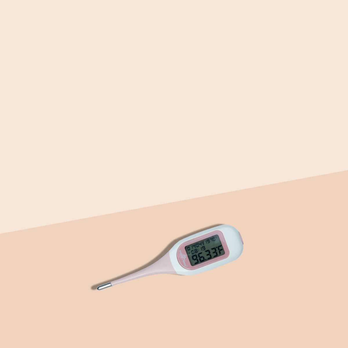 A fertility thermometer on a cream surface