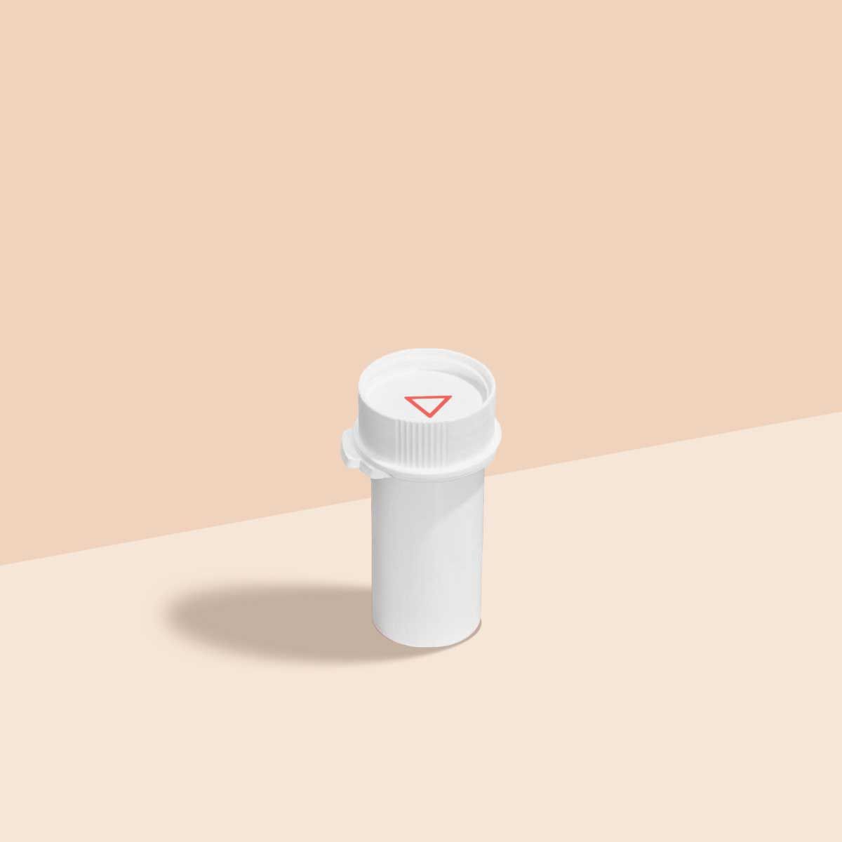 A Wisp pill vial on a cream surface