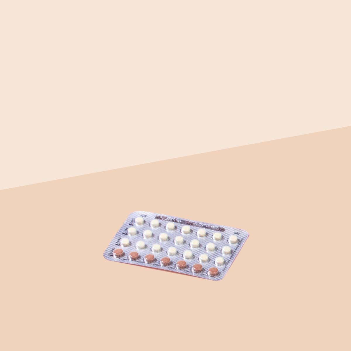 Packet of Trivora birth control pills on a cream background