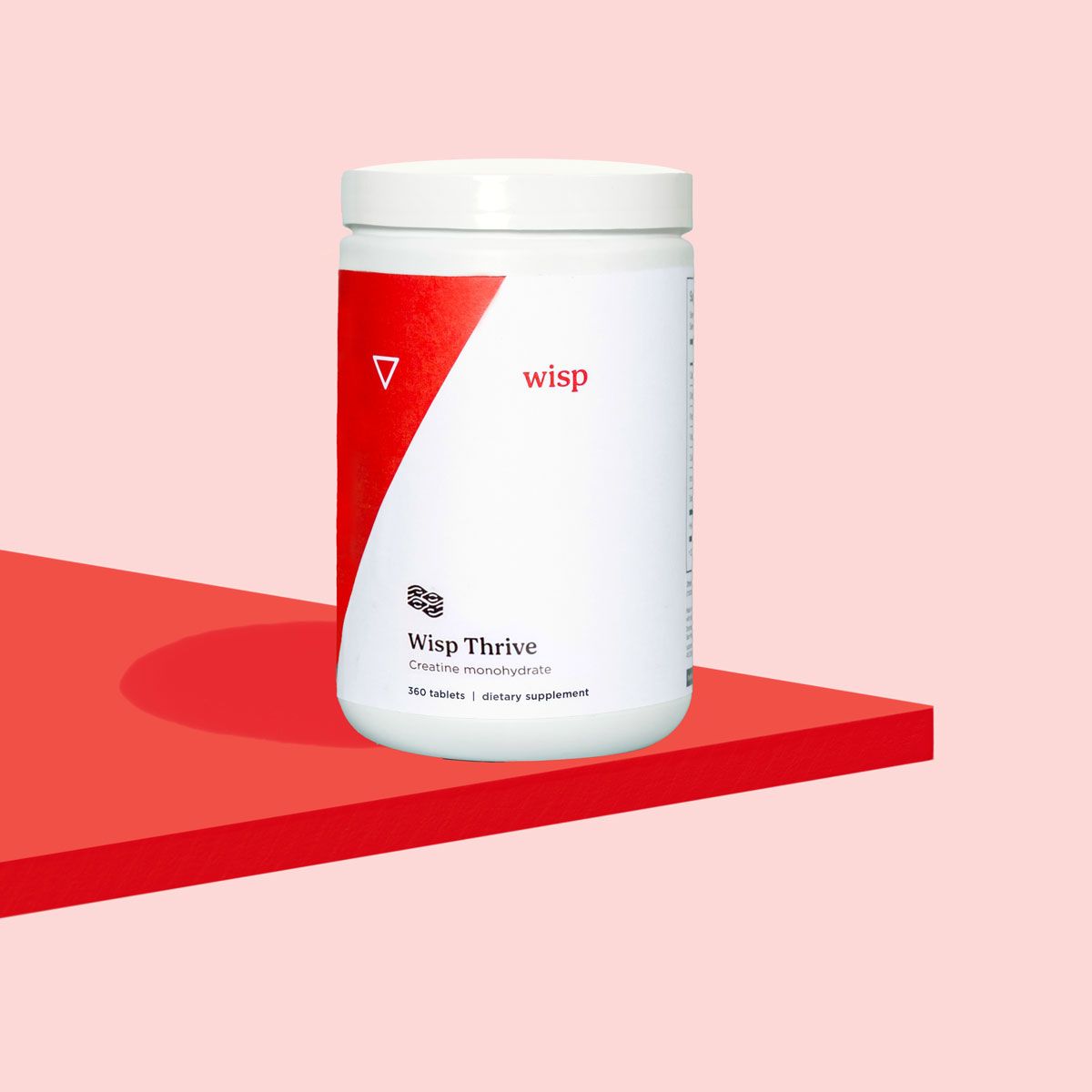 Wisp Thrive Creatine Supplement bottle on a red surface with a pink background